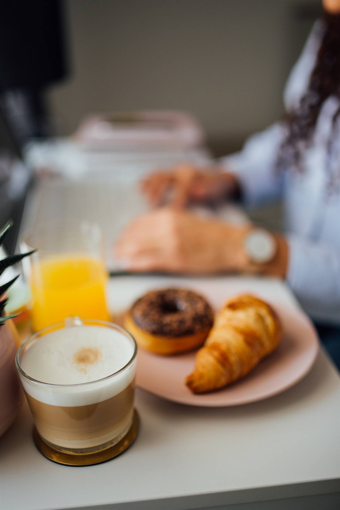Reich gedeckter Frühstückstisch mit Kaffee, Gebäck und frischem Saft